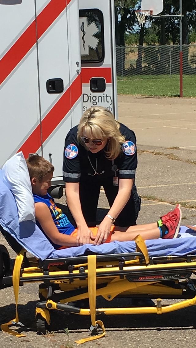 Paramedic talking to child in stretcher